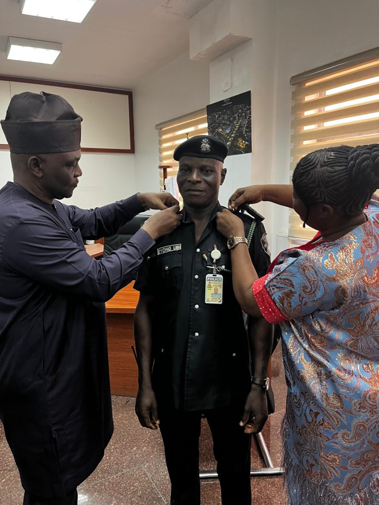 The Executive Secretary, FCDA, Engr. Richard Yunana Dauda decorating Eyong Ubi with his new rank of Assistant Superintendent of Police ( ASP). Supporting on the right is the Officer's wife, Mrs Joy Ubi Eyong