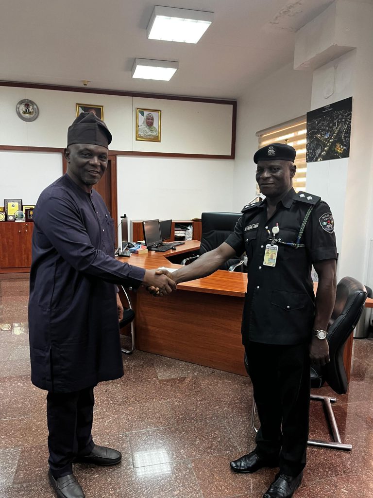 The Executive Secretary congratulating ASP Ubi during his decoration
